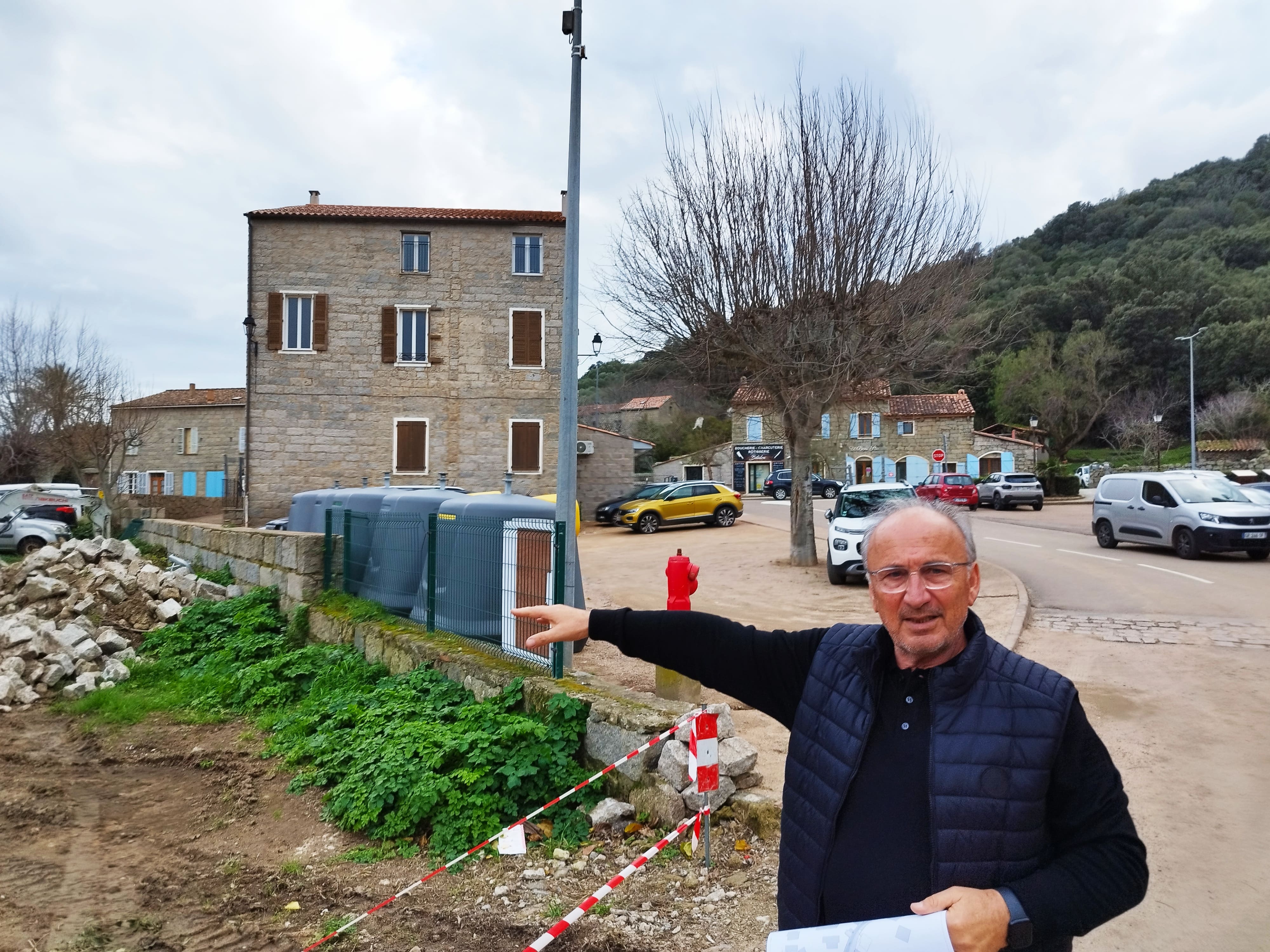 Le maire Jean-Marc Serra montre l'emplacement de la future voirie communale, qui passera de l'autre côté du grand bâtiment où se trouve la salle polyvalente.